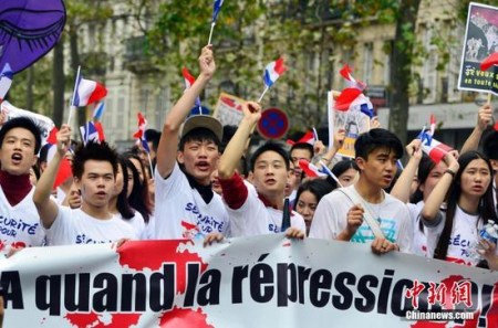 图为参加悼念张朝林、反暴力游行的法国华人奋力发声。