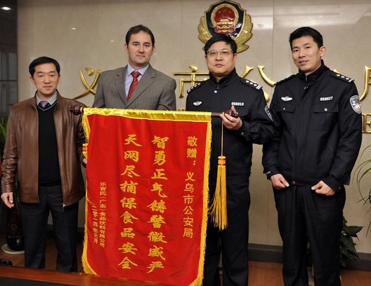 2014年，法国达能集团管理人员给中国民警送锦旗，感谢他们成功破获一起假冒其饮料商标的案件。图片来源：义乌市公安局