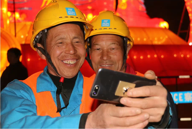 图为湖北省武汉市的工人在元宵节的花灯前用手机分享自拍照。图片来源：人民日报