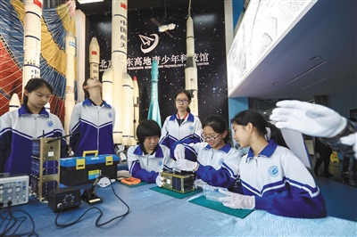 昨日，东高地青少年科技馆，学生正在分组体验拆装1:1卫星模型，老师在一旁指导。新京报记者