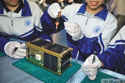 昨日，北京市东高地青少年科技馆，学生在练习拆装1:1卫星模型。新京报记者