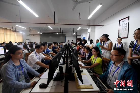 6月15日，位于广西南宁的广西经济干部学院高考评卷点内，工作人员在电脑前阅卷。中新社记者