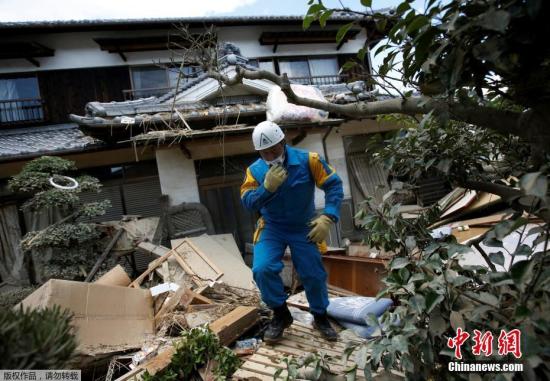 当地时间7月9日，日本冈山县仓敷马比镇，一名警察在检查房屋受损情况。