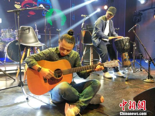 痛仰乐队高虎现场为媒体表演吉他演奏。　何浠　摄