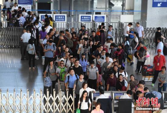 9月28日，福州火车站出行的民众在排队检票进站候车。中新社记者