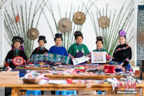 资料图：贵州丹寨，绣娘在合作社展示完成的刺绣作品。2018年，丹寨县非遗手工经济模式共带动全县近8000名绣娘居家就业，脱贫增收。