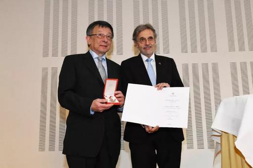 孟昭来博士从奥地利卫生部负责人格哈德·艾格纳博士手中接过“奥地利杰出贡献金质勋章”。（图片来源：法国《欧洲时报》