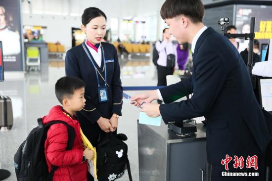 ：1月13日，广州白云机场，地面工作人员陪同无陪儿童前往登机口。