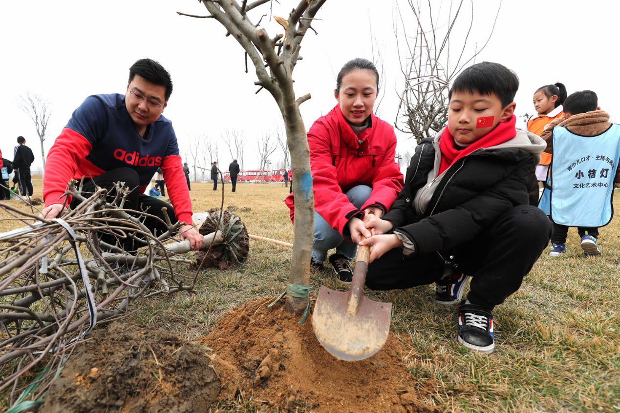2019年3月3日，家长带着孩子在江苏省连云港市赣榆区青口潜园植树。(司伟/人民图片)