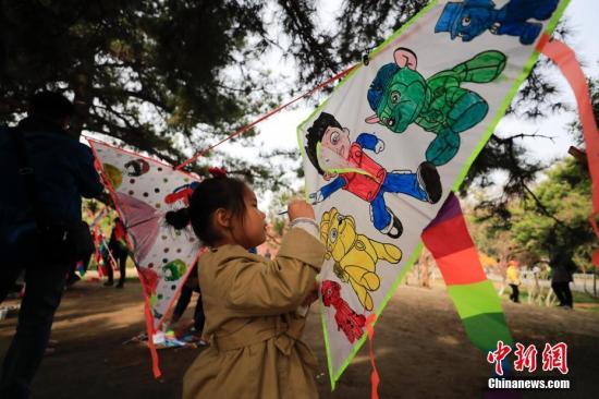 资料图，小朋友在公园内参与“风筝DIY”亲子绘画活动。中新社记者