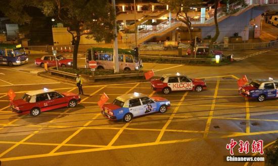 资料图：8月23日晚，“守护香港大联盟”联同香港的士司机从业员总会发起“守护香港·风雨同舟”大行动，在港岛筲箕湾中心，有超过140多辆出租车车身贴着海报，车尾悬挂五星红旗依次有序驶向主干道，呼吁社会反对暴力。中新社记者