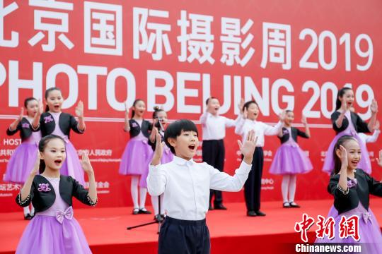 19日，来自三里屯小学的孩子们在北京国际摄影周2019开幕式上合唱《国家》。