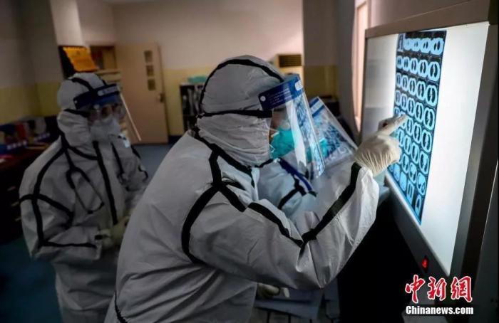 2月3日，在武汉的医务人员查看患者肺部CT片。中新社记者