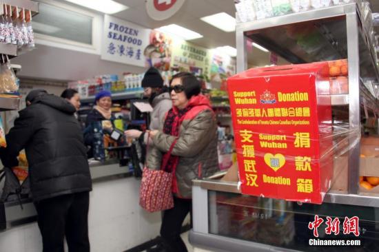 当地时间2月23日，顾客在加拿大多伦多唐人街一间华人超市购物时，从当地侨团为支援中国内地抗击疫情而在店内设置的捐款箱旁走过。超市负责人表示，新型冠状病毒疫情发生以来，华人商区生意受到明显冲击，随着商家、政府等多方努力、宣传，消减民众恐慌情绪，目前超市生意逐渐有所好转。中新社记者