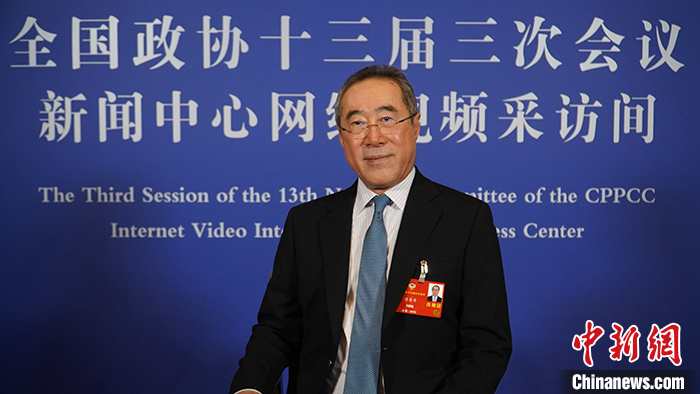 图为唐英年在位于北京华彬费尔蒙酒店内的全国政协十三届三次会议新闻中心网络视频采访间内接受采访。
