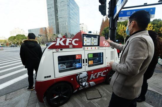 2020年12月17日，市民在摆放上海街头的5G智能无人早餐车前扫码购买早餐。龙巍/人民图片