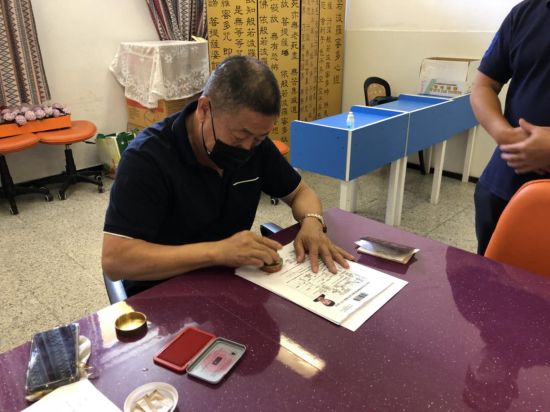 加纳利华人华侨协会志愿者为审核合格的材料加盖协会印章 加纳利华人华侨协会志愿者为审核合格的材料加盖协会印章