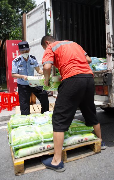 广州一封闭管理区域，民警正在帮忙搬运物资。符超军