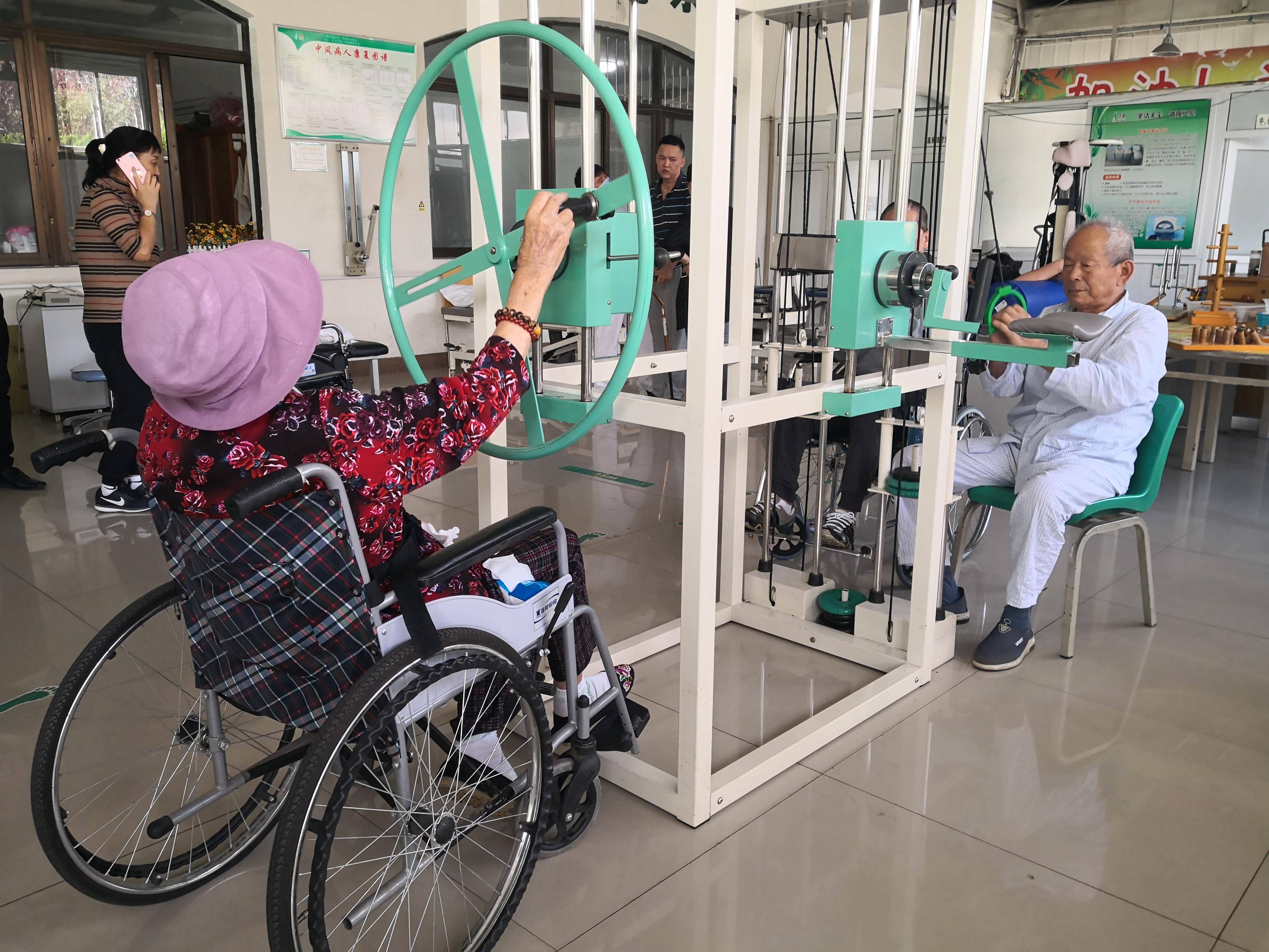 在青岛圣德老年医养院内，老人们正在进行康复锻炼。周伟
