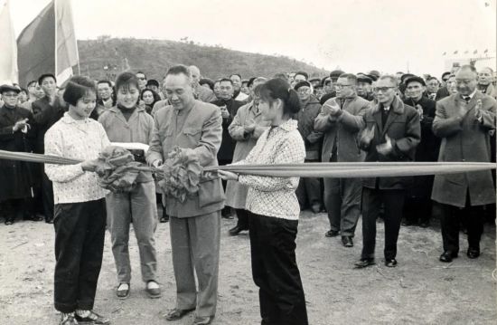 1965年2月27日，广东省副省长林李明在东江—深圳供水首期工程竣工典礼上剪彩。后排右起为香港中华总商会副会长王宽诚、香港工联会会长陈耀材、香港中华总商会会长高卓雄等。