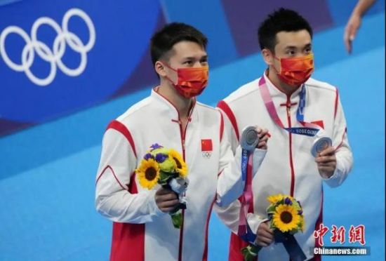 图为7月26日，中国选手曹缘(右)、陈艾森展示奖牌。当日，在东京奥运会跳水男子双人十米跳台决赛中，中国选手曹缘/陈艾森获得亚军。中新社记者 韩海丹 摄