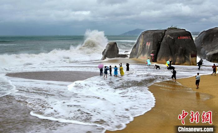 图为近日在三亚天涯海角旅游区嬉浪的游客。游建行