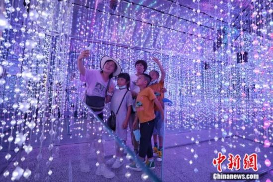 2021年10月，市民在体验馆“黔灵梦幻洞境灯光秀”内自拍。当日是国庆假期，位于贵阳市黔灵山公园外的贵阳人防科普教育体验馆吸引市民前来参观游览。中新社记者 瞿宏伦 摄