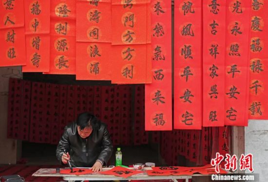 2022年1月,在广西融水苗族自治县汪洞乡,一名书法爱好者正写春联。中新社发 龙涛 摄 2022年1月,在广西融水苗族自治县汪洞乡,一名书法爱好者正写春联。中新社发 龙涛 摄