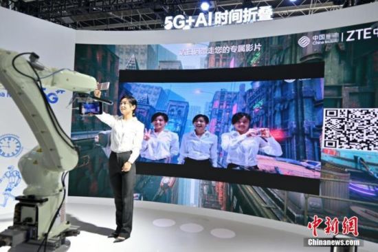 2021年9月7日，河北省石家庄市，参观者体验5G+AI时间折叠后，与视频内3个不同时间的自己自拍留念。中新社记者 翟羽佳 摄