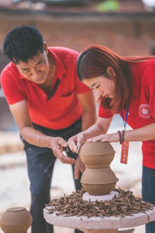 冯太有（左一）正在指导学生对陶胚进行修整