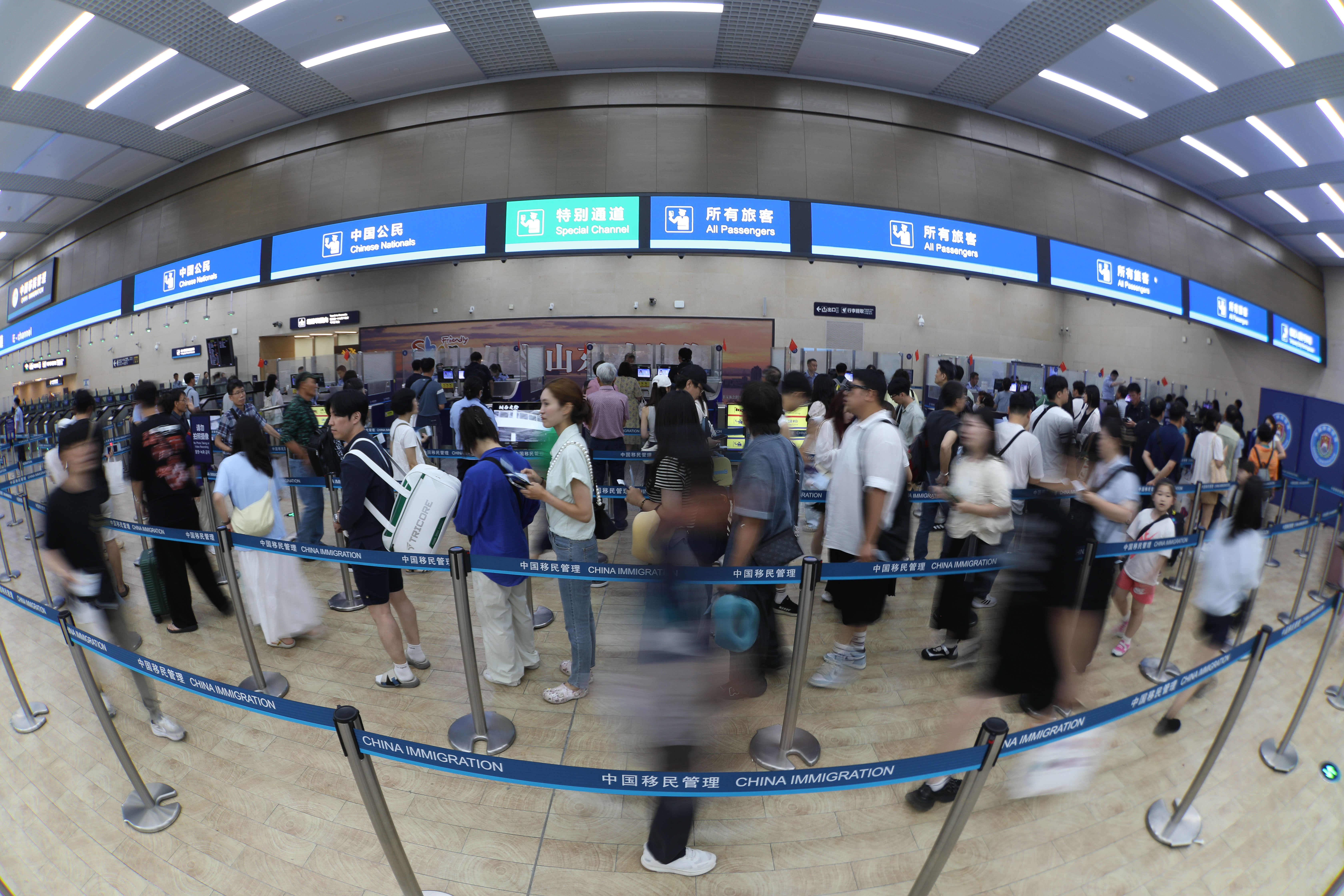 7月30日，旅客在青岛机场边检入境大厅排队通关。