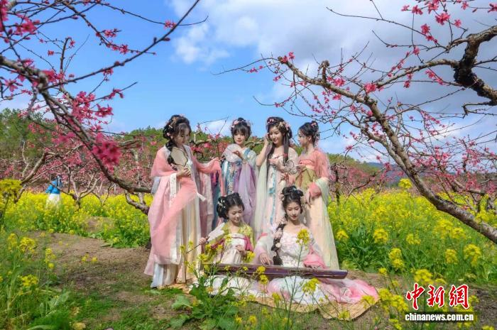 游客在桃园中打卡拍照。邓谦