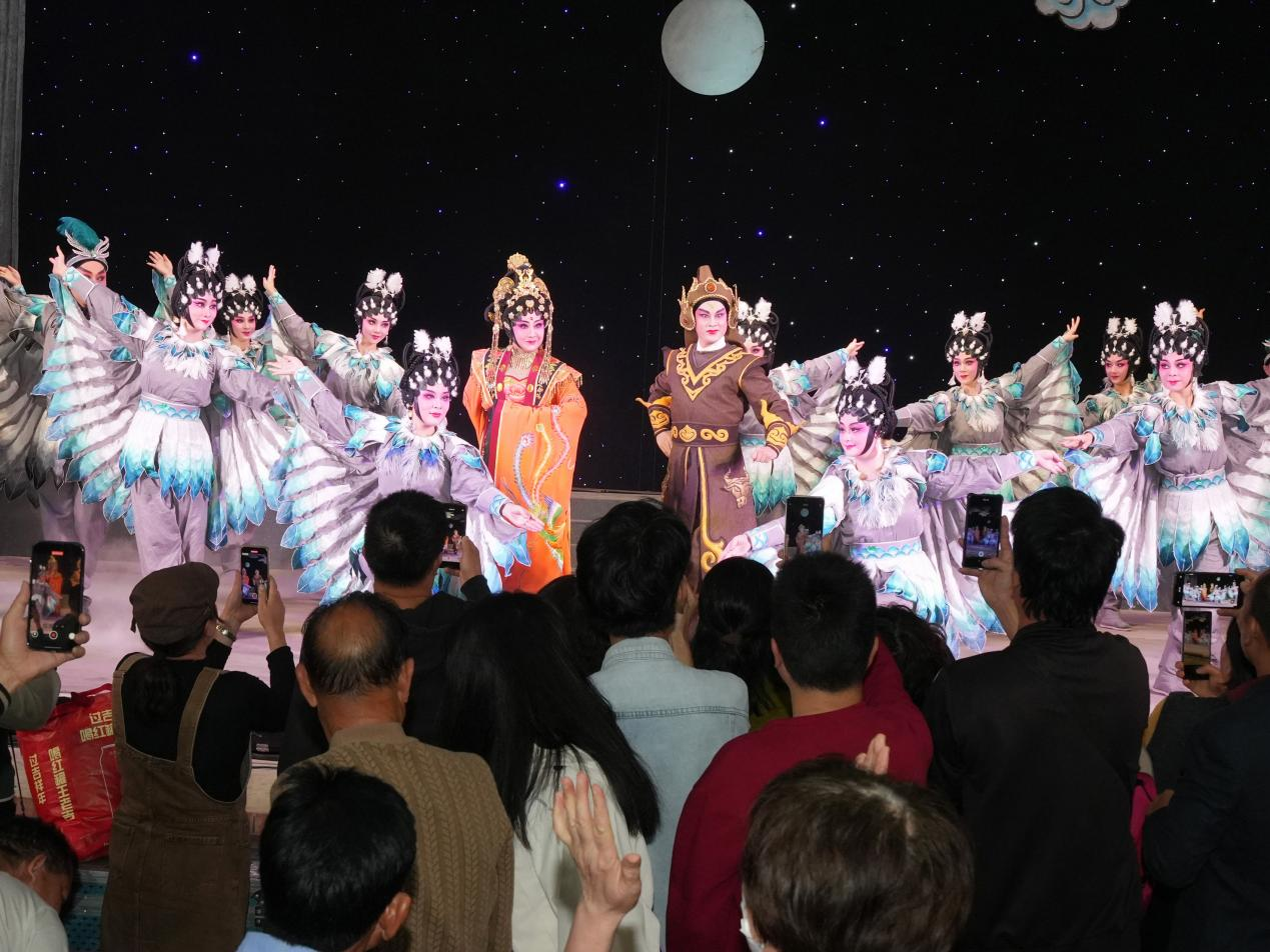 湛江吴川塘㙍镇塘下村，演出即将结束的时刻，前排的当地村民涌到舞台前举着手机拍摄。