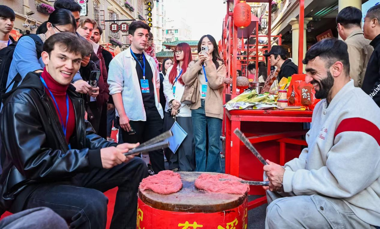 外国游客在汕头体验手打牛肉丸。