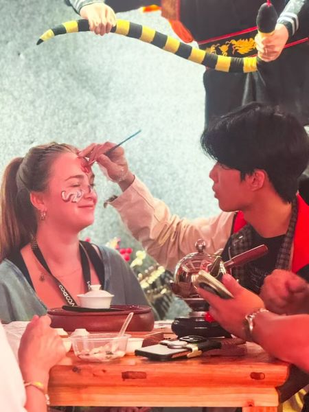 一位化妆师正在为一位外国旅行商化妆，她将学跳英歌舞。受访者供图