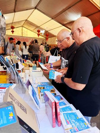 琳琅满目的特色文创产品及出版物吸引中外嘉宾驻足挑选，现场交流气氛热烈。第1眼TV-华龙网记者 张雅萍 摄
