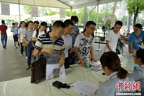 资料图:成都天府新区等一些政务服务中心申请、等待办理落户手续的民众排起长队等待办理。