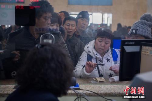 资料图:1月4日,山西太原火车站,旅客在人工售票窗口买到出行的火车票。