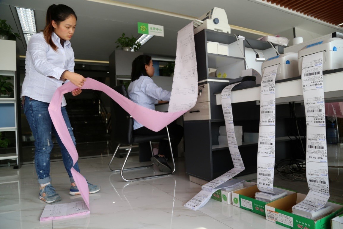 河南省温县鑫合实业电商扶贫产业园的工作人员在打印铁棍山药订单。图片来源：徐宏星/人民视觉