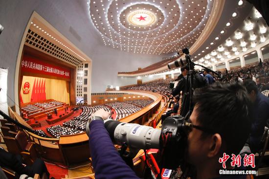 3月13日，十三届全国人大一次会议在北京人民大会堂举行第四次全体会议。图为记者关注会议。
