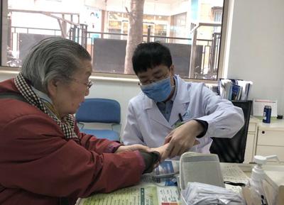 图为北京市新街口社区卫生服务中心社区医生姚弥(右)在为一位居民诊治。本报记者