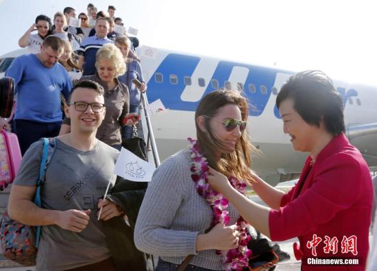 资料图：入境游游客受到热烈欢迎。中新社记者