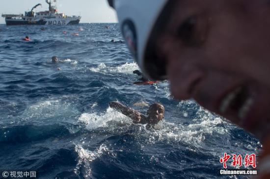 资料图：当地时间2017年5月24日，意大利蓝佩杜萨岛，一艘载着500多人开往意大利的木船翻船后，难民和移民游向救援船。Mario