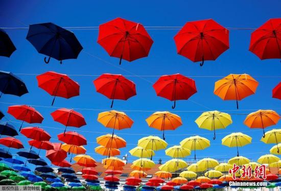 资料图片：奥地利维也纳，杜诺广场挂满彩色雨伞，映衬着蓝天白云，美丽如画。