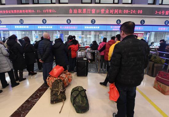 旅客在北京火车站窗口购票、取票。新京报记者