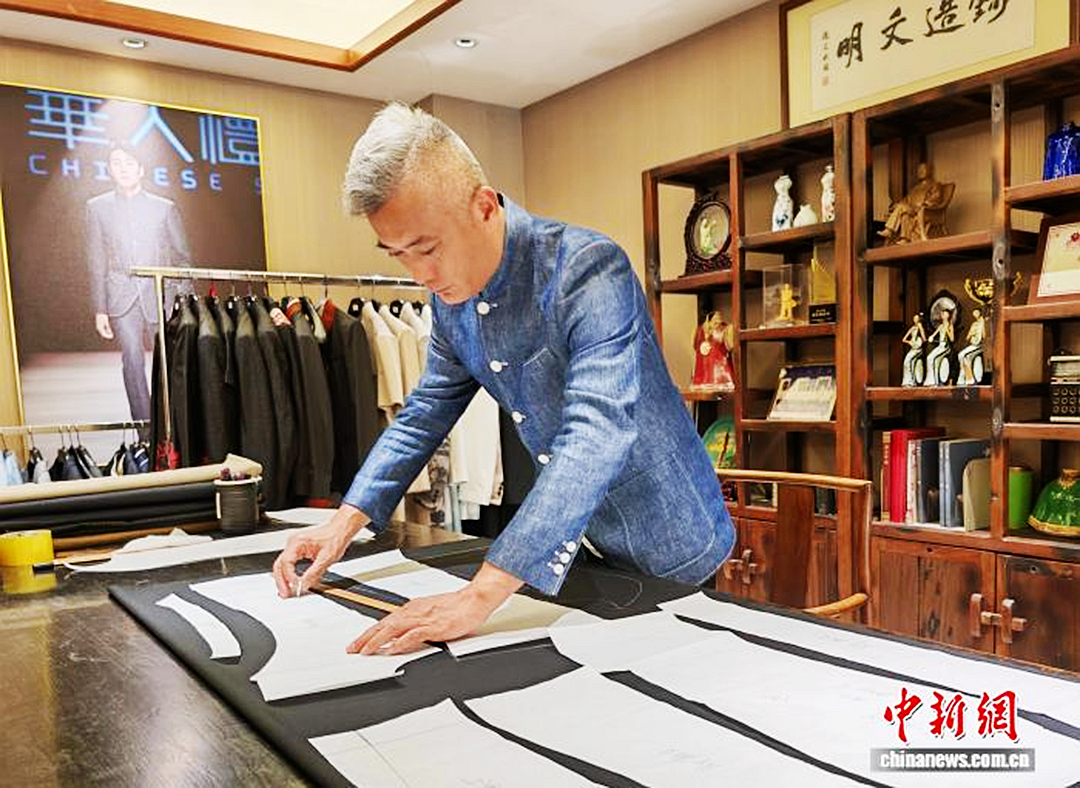 4月18日，广东中山，中山装制作技艺非遗代表性传承人、中山市华人礼服有限公司总经理陈福星正在工坊内裁剪。中新社记者